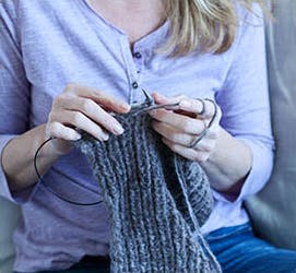 A woman knitting to keep her busy.